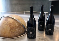 photo of three magnums on the tasting room coffee table that has a globe on it